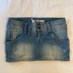 Jeanskjol från Denim Rules - Snygg jeanskjol från Denim Rules i en klassisk blå tvätt. Kjolen har en kort längd med två knappar framtill och fickor både fram och bak. Perfekt till sommaren 🫰💗