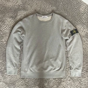Stone island tröja - Säljer en grå stone Island tröja. Tröjan har mycket bra skick och inga defekter✅Nypris är ca 3000. Lappen kan även skannas så man kommer in på hemsidan. Är öppen för byten
