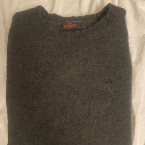 Morris tröja - Säljer en stilren mörkgrå ulltröja från Morris. Tröjan har en klassisk design med långa ärmar och rund halsringning. Perfekt för kyligare dagar och ger en elegant touch till din outfit.