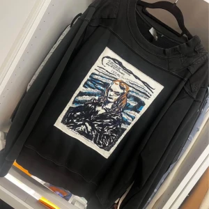 Svart sweatshirt från Dior med konstmotiv - Säljer en svart sweatshirt från Dior med ett unikt konstmotiv på framsidan. Tröjan är tillverkad i bomull och har broderade detaljer. Perfekt för dig som vill ha något stilrent men ändå iögonfallande. Ny pris 15255kr 
