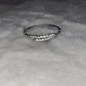 Glittrigt armband i silver - Snyggt armband i silver med glittrande stenar runtom. Perfekt för att ge en extra touch till din outfit. Armbandet är elegant och passar till många olika tillfällen.