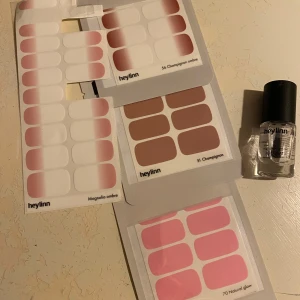 Nagellack från Love'n Layer & Heylinn - Ett sortiment av nagelstickers i olika färger och stilar. Inkluderar även en flaska nagellack. Från love’n layer och heylinn. 3 ark av heylinn är oöppnade, se bild 1.