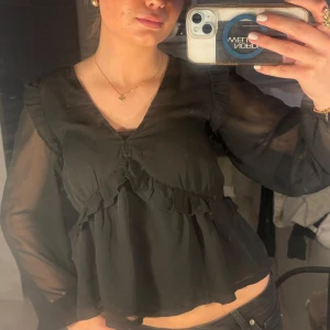 Svart blus från BikBok - Snygg svart blus från BikBok i storlek XS. Blusen har långa ärmar och volangdetaljer framtill. Pris kan diskuteras❤️