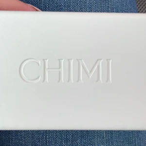 Solglasögon från CHIMI - Snygga solglasögon från CHIMI med en fyrkantig form och transparent brun båge. Designade i Stockholm, dessa glasögon ger en modern och stilren look. Perfekta för soliga dagar!