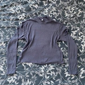 Grå ribbad tröja från H&M Divided - Grå ribbad tröja från H&M Divided. Tröjan har långa ärmar och en hög halsringning samt Töjbart material🌸använd några gånger men bra skick!