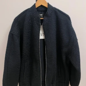 Svart bomberjacka från Zara - Hej! Här säljer jag min helt oanvända marin blå bomberjacka som även fungerar bra för kalla vinterdagar ibland. Den är i storlek XS, men passar även S, så den är väldigt flexibel i passformen. Jackan är i toppskick och har aldrig varit använd, så den är som ny. Perfekt för dig som vill ha något både stiligt och funktionellt. Fler bilder privat och priset kan diskuteras, så tveka inte att höra av dig om du är intresserad!