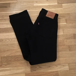 Levi’s 501  - Snygga svarta jeans från Levi's med klassisk design. De har en rak passform (501) och är tillverkade i slitstarkt denim. Perfekta för en stilren look. Se sista bilden för en liten defekt. Skriv i dm vid frågor! 