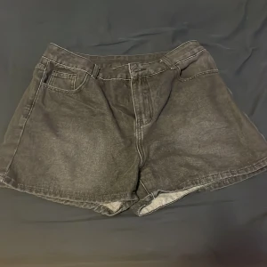 Vintage jorts - Coola svarta jorts med unikt dödskallemotiv med vingar på bakfickorna. Perfekta för en edgy look. De har en klassisk femficksdesign och en bekväm passform.