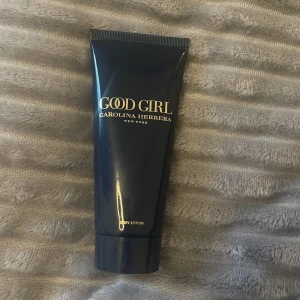 Good Girl Body Lotion från Carolina Herrera - Säljer en lyxig body lotion från Carolina Herrera, Good Girl-serien. Den kommer i en elegant mörkblå tub med guldtext och rymmer 100 ml. Perfekt för att komplettera din doftsamling och ge huden en mjuk och väldoftande känsla.