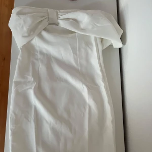 Studentklänning  - Vit fin klänning med en rosett. Perfekt till studenten. Den är aldrig använd 💕😊