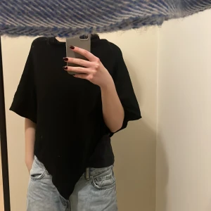 Svart poncho-liknande topp - Säljer en svart poncho-liknande topp. Den har en lös passform utan armar, perfekt för en avslappnad stil. Väldigt skön.