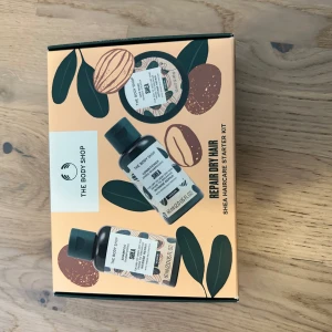 Repair & Nourish Shea Haircare Starter Kit från The Body Shop - Upptäck ett vårdande hårvårdskit med shea från The Body Shop. Innehåller schampo, balsam och hårmask, perfekt för att reparera och ge näring till torrt hår. Praktiska resestorlekar i en snygg förpackning.