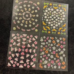 3D Nagelklistermärken med blommor och fjärilar - Set med nagelklistermärken i olika blommönster och fjärilar. Färgerna inkluderar rosa, blå, gul, orange och vit. Perfekt för att dekorera naglarna med en färgglad och lekfull stil.  45kr/4ark/bild , samma frakt 