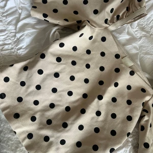 Beige prickig topp från H&M - Säljer en söt beige topp med svarta prickar från H&M. Toppen har trekvartsärm och så fin skärning vid halsen😍 säljer då den är för liten för mig