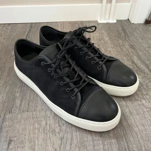 Sneakers från Tiger of Sweden - Snygga svarta sneakers i mocka och skinn från Tiger of Sweden. Storlek 43. Använda ca 10 ggr.