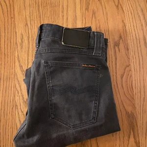  Nudie Jeans - Snygga svarta jeans från Nudie Jeans med en klassisk femficksdesign. De har en rak passform och är tillverkade i ett slitstarkt denimtyg. Perfekta för en stilren look. Det är svart och grå 