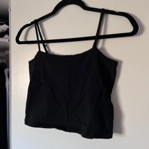 Svart linnetopp - Snygg svart linnetopp från Lager157 i storlek M. Tillverkad av 95% bomull och 5% elastan för en bekväm passform. Perfekt för varma dagar eller som ett lager under en jacka. Önskar du veta exakta mått? Tveka inte att höra av dig!