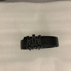Amiri bälte  - Snyggt svart bälte från Amiri med ett unikt och iögonfallande spänne. Tillverkat i skinn och kommer i originalförpackning från StockX. Perfekt för att ge din outfit en edgy touch bästa kopiorna i svergie medföljer stockX verifiering 