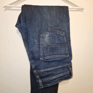 Blå jeansbyxor från Tiger of Sweden  - Snygga blå jeans från Tiger of Sweden som är väldigt sparsamt använda. Perfekta för en avslappnad stil.