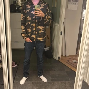 Camouflagejacka från Valentino - Säljer en snygg camouflagejacka från Valentino. Jackan har en cool design med dragkedja och huva, perfekt för en avslappnad stil. Tillverkad i Italien med högkvalitativt material. Passar perfekt för dig som vill sticka ut med ett trendigt mönster.