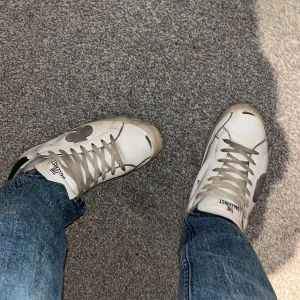Vita sneakers med gröna detaljer - Snygga vita sneakers med gröna detaljer och gråa mönster. Skorna har snörning och en klassisk design som passar perfekt till jeans. Perfekta för en avslappnad stil. Köpta för 2000kr är i storlek 41 men passar 42 förhandlingsbart pris