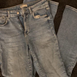 Ljusblå jeansbyxor - Snygga ljusblå jeansbyxor med klassisk femficksdesign och knappgylf. Perfekta för en avslappnad stil. De har en rak passform och är tillverkade i ett bekvämt denimtyg.