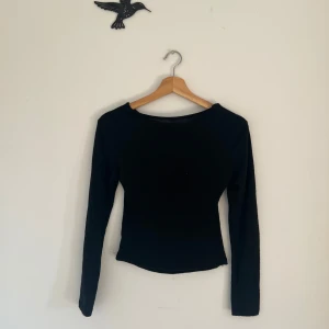 Svart långärmad topp med öppen rygg  - Säljer en svart långärmad topp från Missäy med en stor öppen ryggdetalj. Toppen har en tight passform och är perfekt för att skapa en stilren och trendig look.