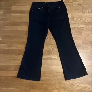 Svarta bootcut jeans från Trifari Jeans - Säljer ett par svarta lowwaist bootcut jeans från Trifari Jeans med dekorativa metallringar vid fickorna. Jeansen har skit fina bakfickor och framfickor. Priset kan diskuteras 🩷