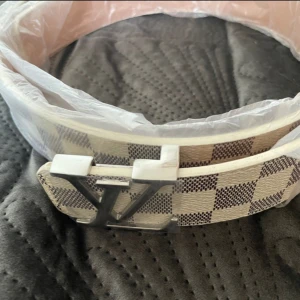 Vit och grå bälte med rutigt mönster - 105cm lång 