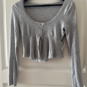 Grå tröja  - Grå tröja från Gina tricot i storlek S, använd fåtal gånger, u ringad med en rosett i mitten. 