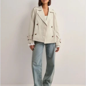 Beige trenchcoat - Snygg beige trenchcoat med dubbelknäppning och bälte i midjan som är lätt att ta bort, sitter alltså inte fast i jackan! 🥰 Den är använd typ 2 gånger så väldigt ny och i gott skick❤️