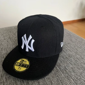  New Era New York Yankees keps - Klassisk svart New Era 59FIFTY keps med New York Yankees-logga framtill och World Series-märke på sidan. Den är liten i storlek så typ 59 cm