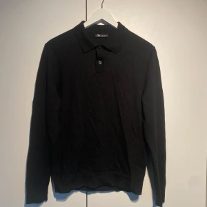 Zara stickad pikétröja svart - Säljer en svart stickad pikétröja från Zara med klassisk krage och knappslå framtill. Tröjan har lång ärm och är perfekt för en stilren och enkel look. Passar dig som gillar basic men ändå vill ha något lite mer dressat. Storlek M men passar mindre så XS/S. Välanvänd men i fint skick.  