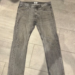 Grå raka jeans från lager 157 - Säljer ett par grå jeans från lager 157 med klassisk femficksdesign och raka ben. Jeansen har en diskret tvättad look och normal passform. Perfekta till vardags för en avslappnad stil.