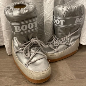 Silvriga boot boots med snörning - Obs! Inte moonboots! Läs bio❤️Säljer ett par silvriga ”boot boot” skor (liknar moon boots men har texten boot x3) .  Lite smutsiga och med några få skavanker här o där men annars fina. Storlek 38/40