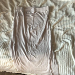 Beige långkjol från 157 - Säljer en beige långkjol från 157 i mjukt och lätt material. Kjolen har en rak passform och bred resår i midjan och är ribbad på sidan, säljer för att har inte används på 2 år nu och kommer inte ha användning. Det är storlek L men den syns inte på kjolen eftersom jag klippte av lappen. Den är lite skrynklig så den behövs strykas 