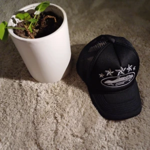 Svart Corteiz keps  - 📊Färg: Kepsen är svart med ett vitt corteiz märke på framsidan. Över märket finns det fem vita stjärnor, vilket också finns på högra sidan av kepsen!!  📏Storlek(All sizes): Kepsen storlek går att justera, vilket betyder att den passar allas huvud.  ♻️Kvaliteten: Kepsen är riktigt bra kvalitet. Endast använs ett par gånger. Det finns inga märken och inga fläckar.  🧾Priset: Priset kan diskuteras, men det går inte att dra ner på Priset för mycket.  🧺Material: Materialet är mestadels Bomull. 