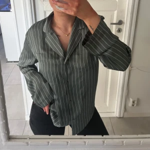 Skjorta  - Det är en pyjamas skjorta men går att använda som en vanlig skjorta då det ser ut som en, satin är materialet. Finns två små fläckar se bild nmr 2. Ej provat om de går bort