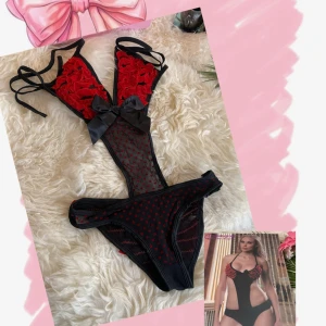 Svart och röd spetsig bodysuit med rosetter - Säljer en svart bodysuit med röda spetsdetaljer och stora svarta rosetter framtill🩷