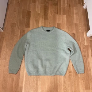 Grön stickad tröja från ASOS  - Säljer en stilren grön stickad tröja från ASOS. Tröjan har rund halsringning, långa ärmar och ribbade muddar vid ärmslut och nederkant. Oversize fit
