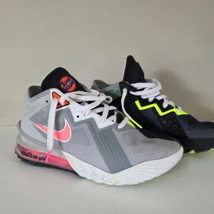 Nike LeBron 18 Low x Tune Squad - Unika Nike LeBron 18 Low basketsko i samarbete med Tune Squad. Skorna har en mix av grå, svart, vit och neon-gul färg med rosa detaljer och broderade Tune Squad-loggor. Snygg split-design och coola detaljer på hälen och sulan. Endast använda ett fåtal gånger så mycket bra skick! 