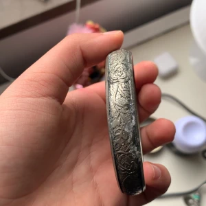 Silverfärgat armband med graverat blommönster - Säljer ett snyggt armband i silverfärg med graverade blommor och detaljerade mönster. Perfekt accessoar för att lyfta din stil. Passar de flesta handleder.