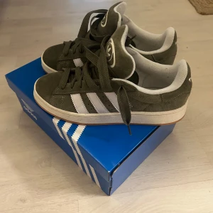 Adidas Campus sneakers i olivgrön mocka - Säljer ett par Adidas Campus sneakers i olivgrön mocka. Skorna är använda fåtal gånger och är i nyckskick! Storlek 42 2/3 