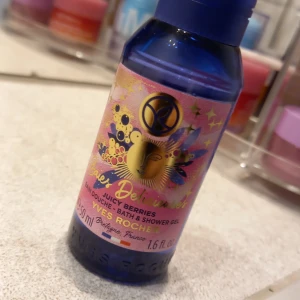 Juicy Berries Bath & Shower Gel från Yves Rocher - En blå plastflaska med duschgelé från Yves Rocher i doften Juicy Berries. Flaskan har ett färgglatt etikett med guldiga detaljer och bärmotiv. Innehåller 50 ml och är perfekt för resan eller gymväskan.