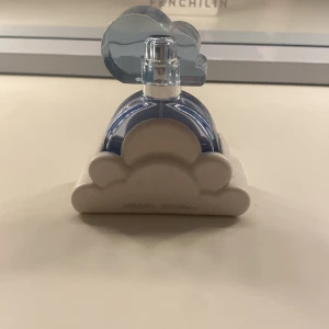 Cloud Eau de Parfum från Ariana Grande - Säljer en parfymflaska från Ariana Grande, modellen Cloud. Flaskan är rund och blå med ett lock i form av ett blått moln och står i en vit molnformad hållare. Perfekt för dig som gillar söta och fräscha dofter. Säljer då den ej kommer till användning längre. Ca hälften kvar därav lägre pris. 