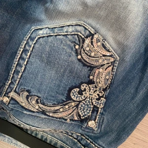 Miss me jeans!💋💗 Blå bootcut jeans med broderad bakficka och slitningar - Jag säljer ett par blå miss me jeans som är bootcut och med snygga slitningar framtill och detaljerad broderad bakficka med paljetter. Jeansen har normal passform och perfekt för dig som gillar extra detaljer på dina jeans. Dom är som nya och är i storlek 28!💗 39 cm rätt över midjan och längden är 80💗Pris kan diskuteras, skriv om ni har frågor! 