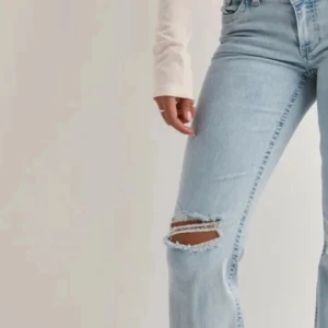 Ljusblå bootcut jeans - Lågmidjade Ljusblå jeans med bootcut passform och slitning vid ena knät. Klassisk modell med normal midja och dragkedja. Pris kan diskuteras 💕