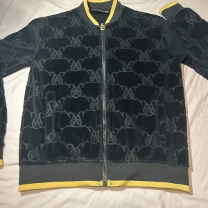 Svart bomberjacka från SikSilk med gulddetaljer - Säljer en svart bomberjacka från SikSilk med gulddetaljer. Storlek ax passar även S också 