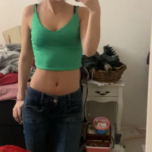 Grön croppad linnetopp - Säljer en grön croppad linnetopp med smala axelband. Toppen har en tight passform och är perfekt för varma dagar. Enkel och stilren design som passar till mycket.