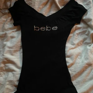  Bebe topp - Bebe topp som sitter jättefint, den är väldigt stretchig och passar xs/s. Vill egentligen inte sälja men behöver pengar!! (Äkta Bebe) #Bebe #y2k #drainer #avantgarde #emo #bebe